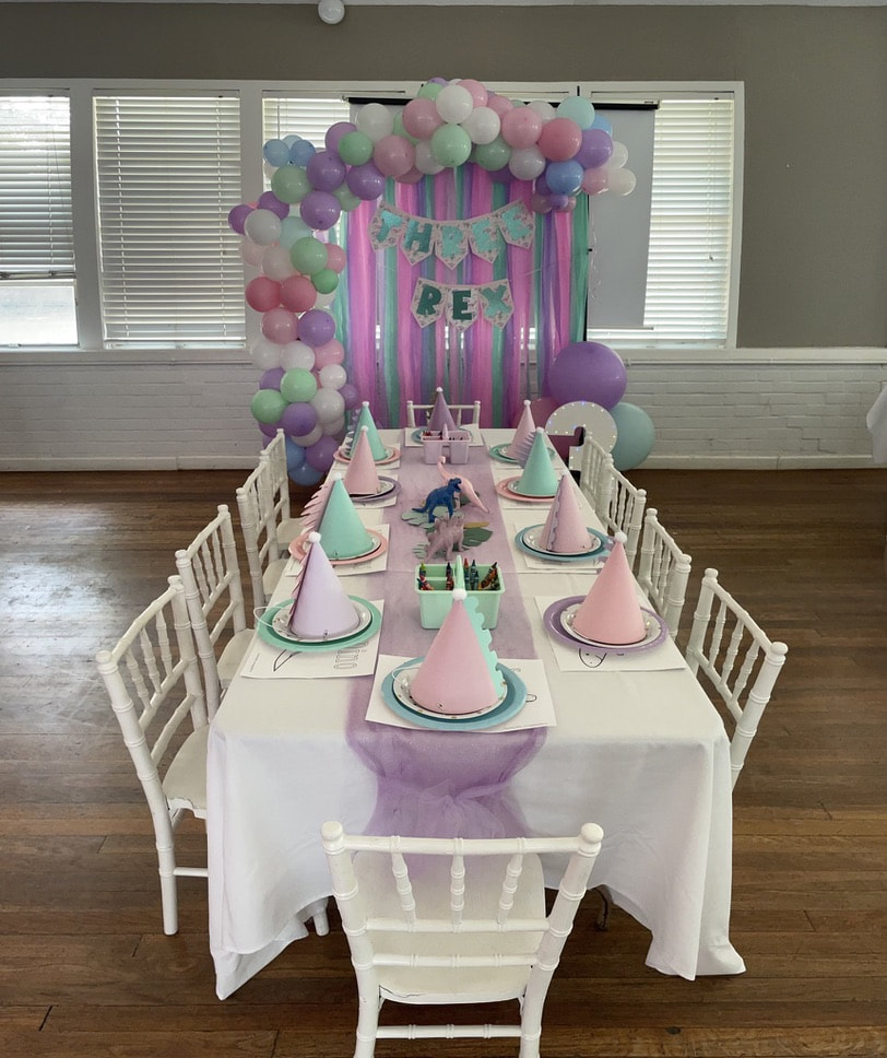 Birthday party table setup with balloon arch