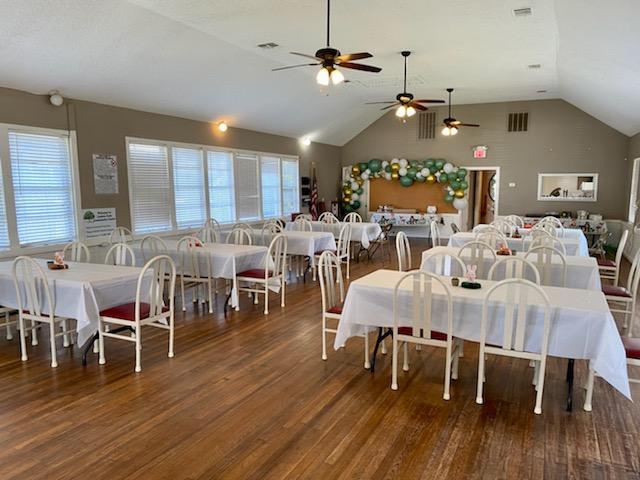 Banquet-style seating with white linens and vaulted ceiling